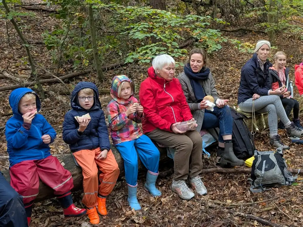 Mehrere Familien picknicken beim Familienausflug im Wald.