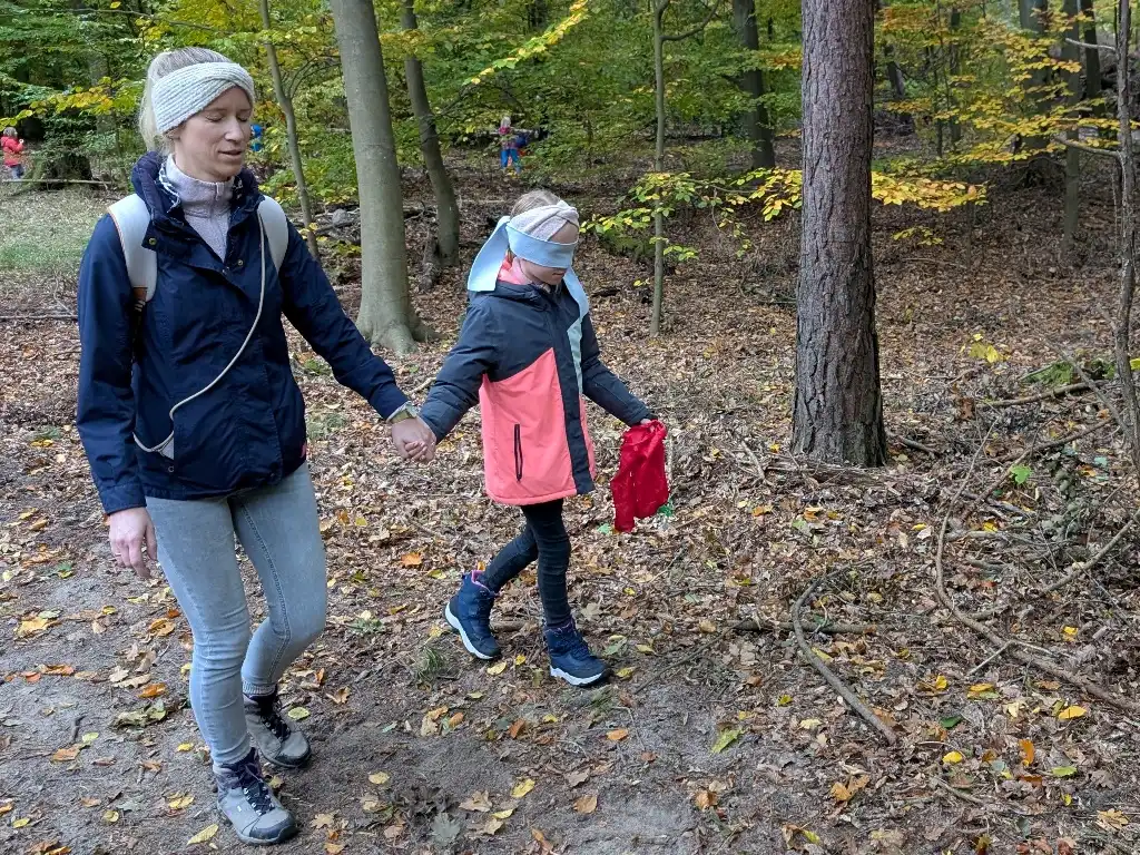 Eine Mutter läuft mit ihrer Tochter blind durch den Wald.